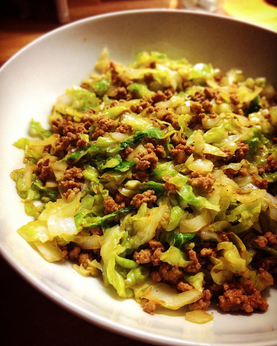 Close-up of a white bowl filled with a savory Ground Turkey Cabbage Skillet, featuring browned ground turkey and sautéed green cabbage.