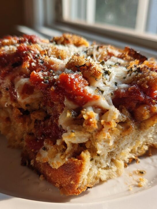 A thick, baked slice of My Italian Grandmothers Eggplant Recipe topped with red sauce and melted cheese.