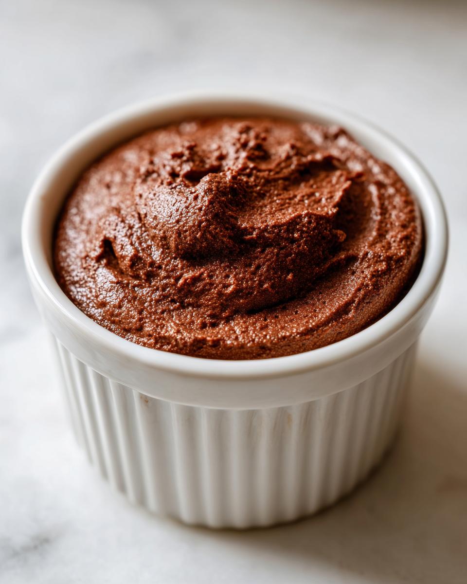 Close-up of rich, dark chocolate cottage cheese mousse served in a white fluted ramekin.