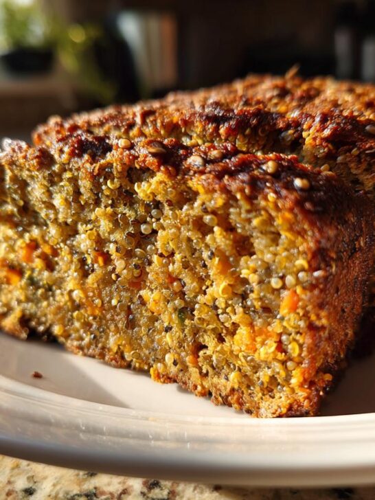 A close-up of a thick slice of Seedy Goodness Quinoa Lentil Loaf showing texture and grains.