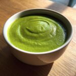 Close-up of a creamy, vibrant bowl of Green Goddess Soup Recipe with a swirl on top.